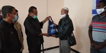 Anggota Komisi IV DPR RI, Sulaeman L Hamzah sedang menyerahkan kantong plastik berisi ikan- FOTO : Fransiskus Labi Kobun