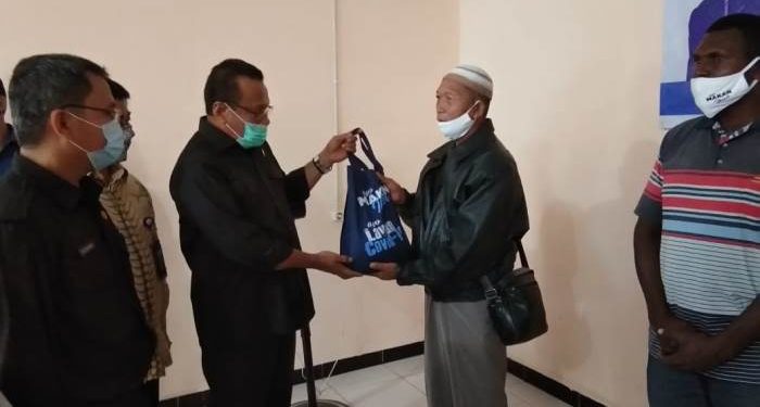 Anggota Komisi IV DPR RI, Sulaeman L Hamzah sedang menyerahkan kantong plastik berisi ikan- FOTO : Fransiskus Labi Kobun